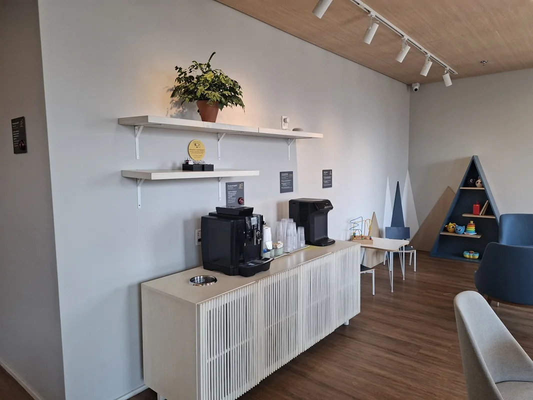 Sala de espera do consultório  com café e brinquedos ao fundo.